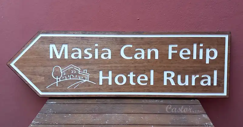 Cartel de madera en forma de flecha indicadora para hotel rural